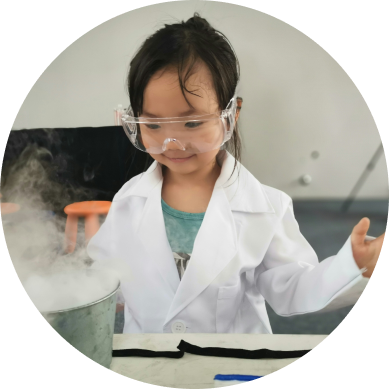 A round image of a little girl doing a science experimment